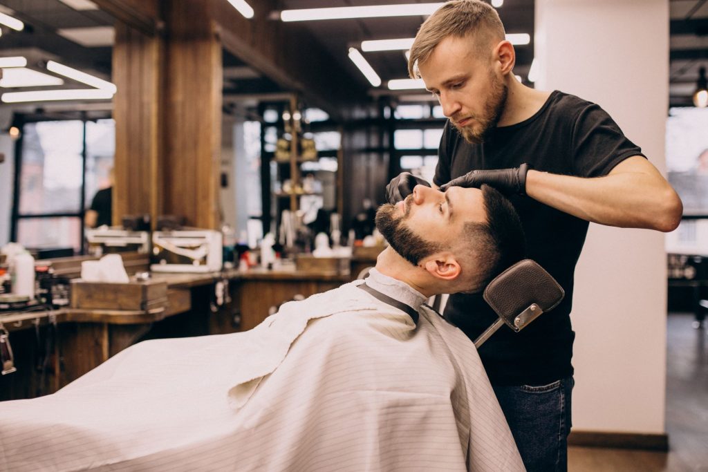 Man in barbershop getting a haircut and beard trim