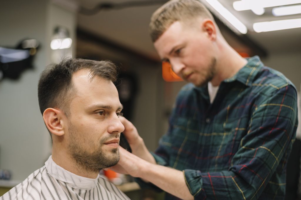 man with thinning hair getting a haircut with shorter sides and longer top