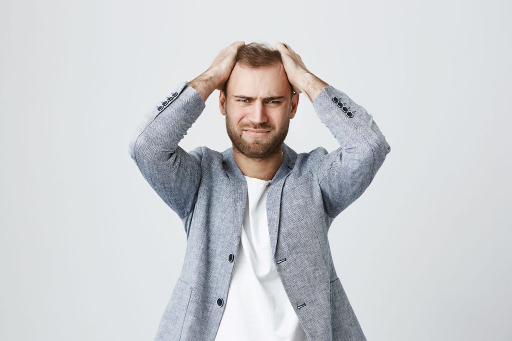 Man frustrated with product build-up on his scalp